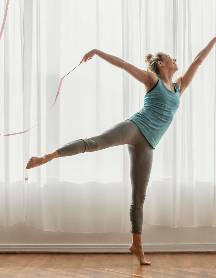 Woman performing active rhythmic exercises in a modern studio setting.